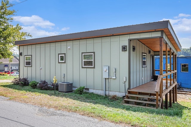 view of outbuilding with a lawn and central air condition unit