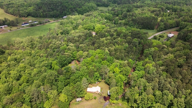 aerial view of property and surrounding area with a heavily wooded area