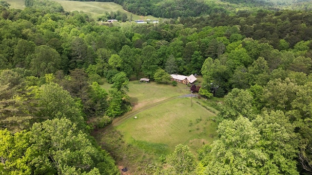 aerial view of property and surrounding area featuring a heavily wooded area and rural landscape