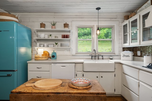kitchen featuring dishwasher, freestanding refrigerator, a sink, white cabinets, and light countertops