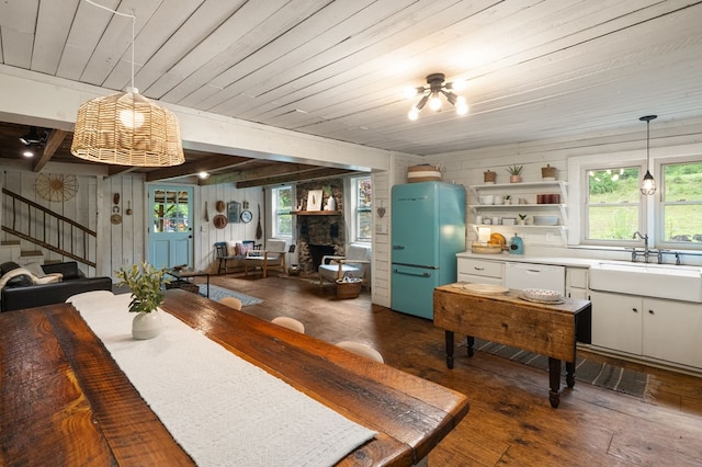 dining space featuring a fireplace, hardwood / wood-style floors, stairway, plenty of natural light, and wood walls