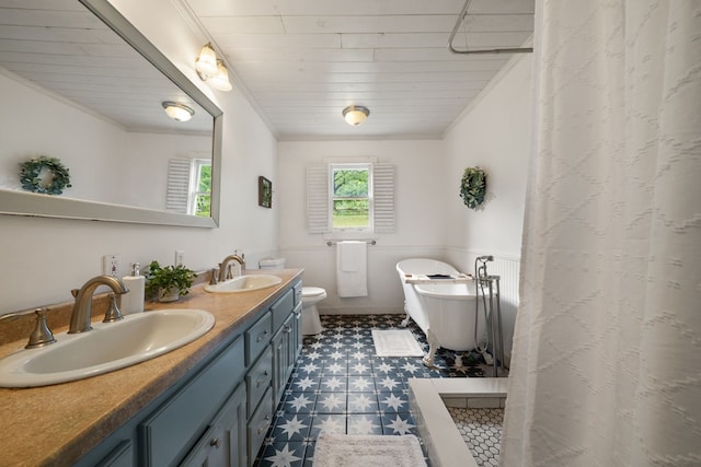 full bath featuring tile patterned floors, wainscoting, crown molding, a freestanding bath, and double vanity