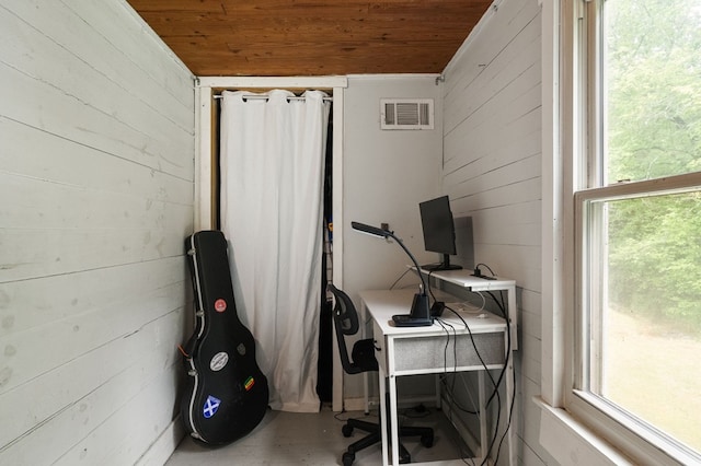 home office with wood ceiling, wood walls, and concrete floors
