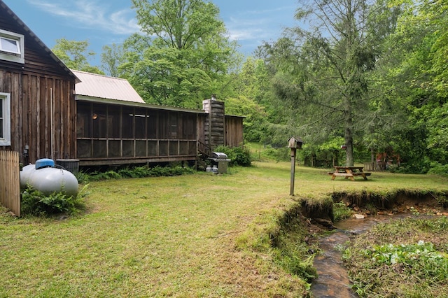 view of grassy yard featuring a sunroom