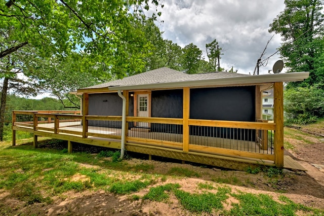 rear view of property with roof with shingles and a deck
