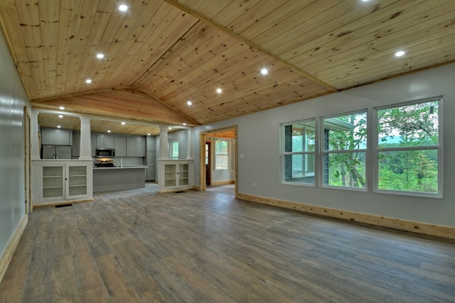 unfurnished living room featuring wood finished floors, vaulted ceiling, baseboards, and recessed lighting
