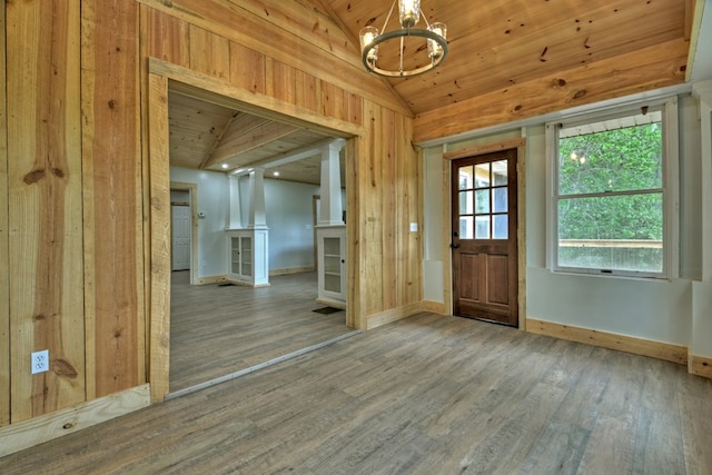 foyer entrance featuring vaulted ceiling, wood finished floors, and baseboards