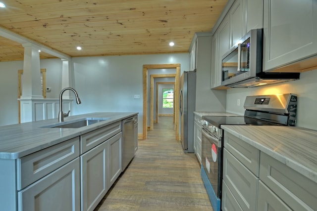 kitchen with light wood finished floors, a sink, recessed lighting, wooden ceiling, and appliances with stainless steel finishes