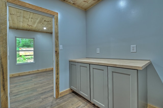 interior space featuring wooden ceiling, baseboards, and wood finished floors