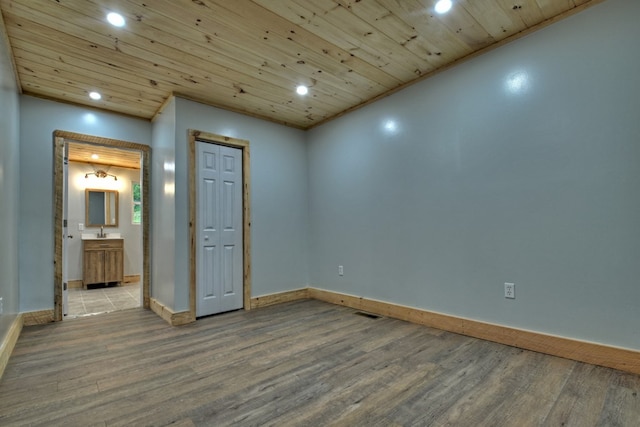 unfurnished room with a sink, baseboards, recessed lighting, wood finished floors, and wood ceiling