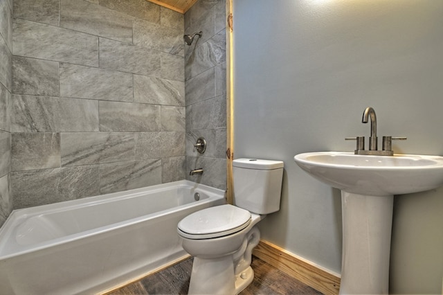 full bath with wood finished floors, shower / bathtub combination, toilet, a sink, and baseboards