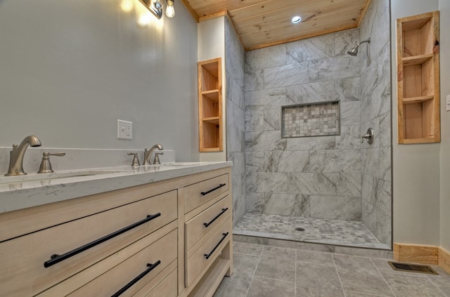 full bath featuring tiled shower, baseboards, visible vents, wood ceiling, and vanity