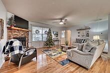 living room with a fireplace, hardwood / wood-style flooring, and ceiling fan