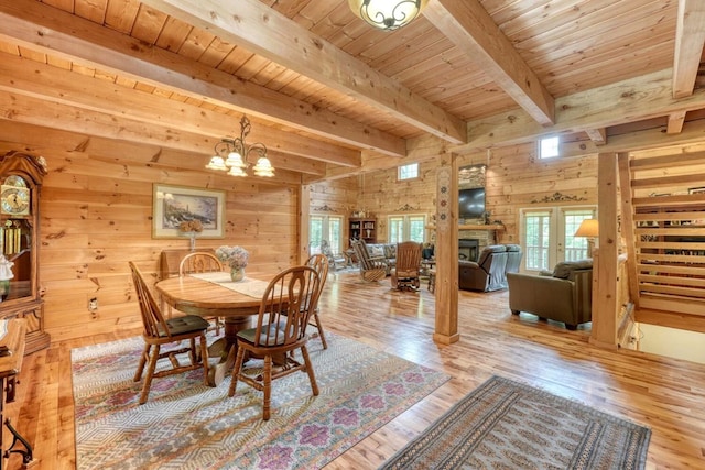 dining space with plenty of natural light, wooden walls, light hardwood / wood-style floors, and wooden ceiling