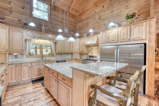 kitchen with appliances with stainless steel finishes, a center island, and light brown cabinetry