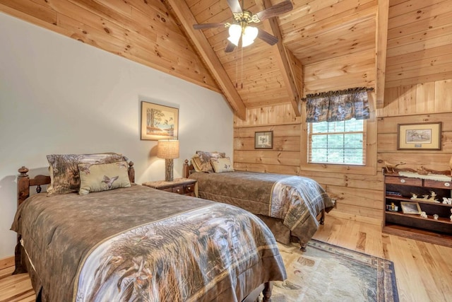 bedroom with light hardwood / wood-style flooring, ceiling fan, lofted ceiling with beams, wooden ceiling, and wood walls