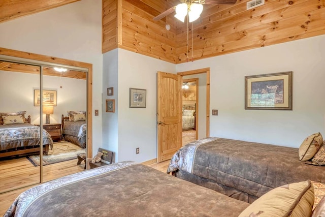 bedroom featuring hardwood / wood-style floors, a closet, and a high ceiling