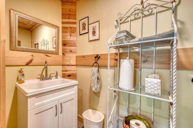 bathroom featuring vanity and wooden walls