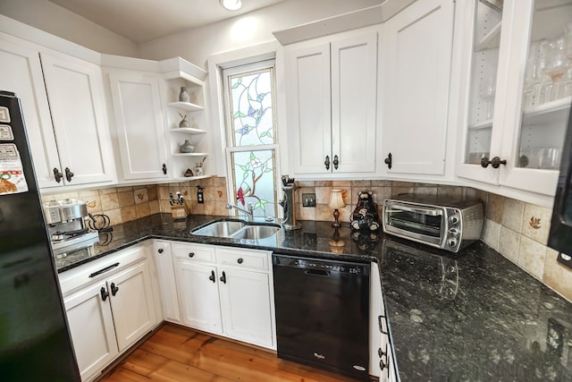 kitchen featuring sink, tasteful backsplash, black appliances, white cabinets, and dark stone counters