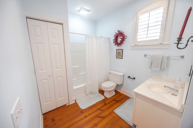 full bathroom featuring vanity, wood-type flooring, shower / tub combo, and toilet