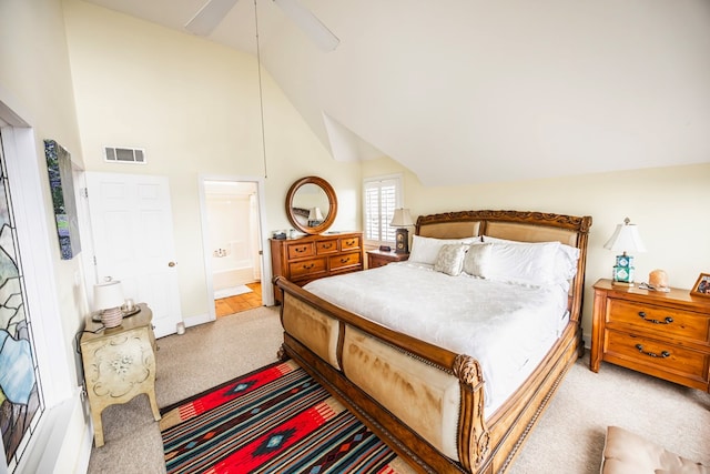 bedroom with ceiling fan, connected bathroom, vaulted ceiling, and light carpet