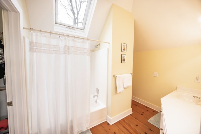 bathroom with lofted ceiling, hardwood / wood-style floors, vanity, and shower / tub combo with curtain