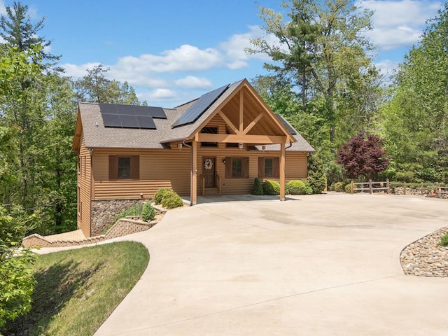 1172 Settlers Ridge Rd, Ellijay, GA 30540 - view of front facade featuring roof with shingles, solar panels, covered porch, and stone siding