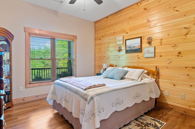1172 Settlers Ridge Rd, Ellijay, GA 30540 - bedroom featuring light wood-style floors, wood walls, ceiling fan, and baseboards