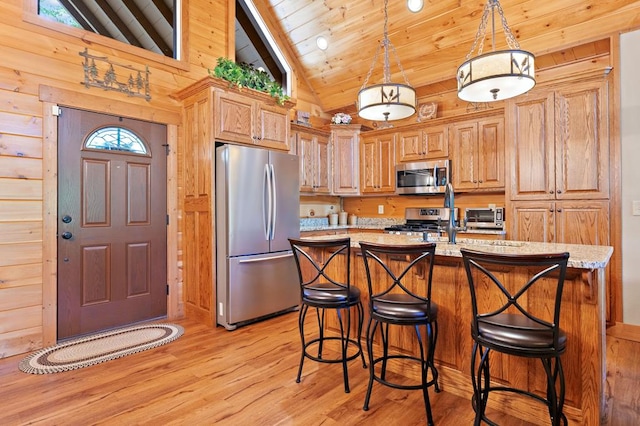 1172 Settlers Ridge Rd, Ellijay, GA 30540 - kitchen with appliances with stainless steel finishes, light wood-style flooring, a breakfast bar area, pendant lighting, and a kitchen island with sink