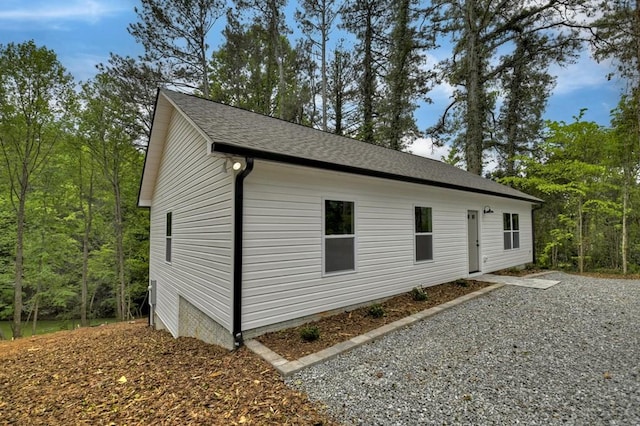 view of side of property featuring roof with shingles