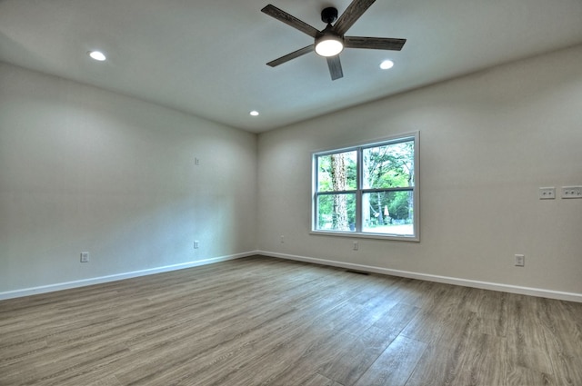spare room with baseboards, ceiling fan, recessed lighting, and wood finished floors