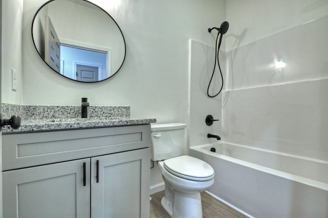full bath with vanity, wood finished floors, toilet, baseboards, and shower / bathing tub combination
