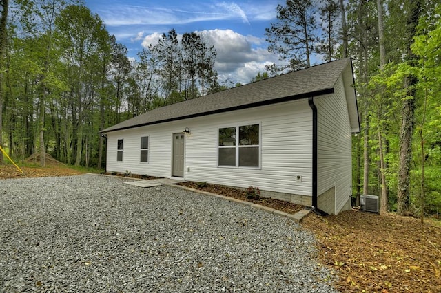 view of front of house featuring a shingled roof and central AC