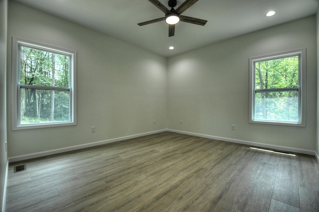 spare room featuring ceiling fan, recessed lighting, baseboards, wood finished floors, and visible vents