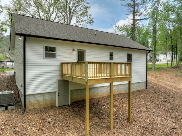 back of property with cooling unit, a wooden deck, and a shingled roof
