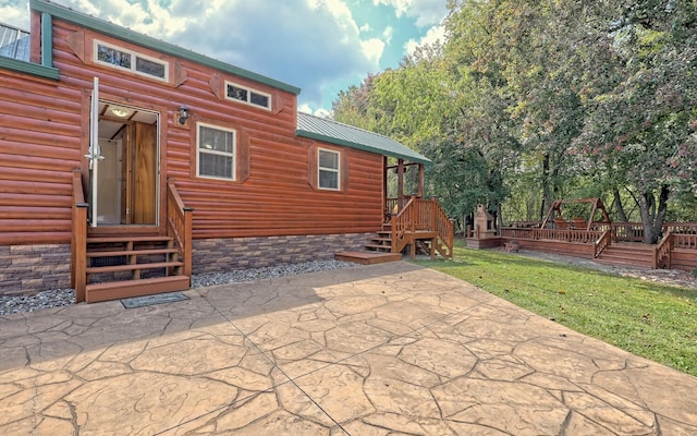 rear view of property with a deck and a patio area