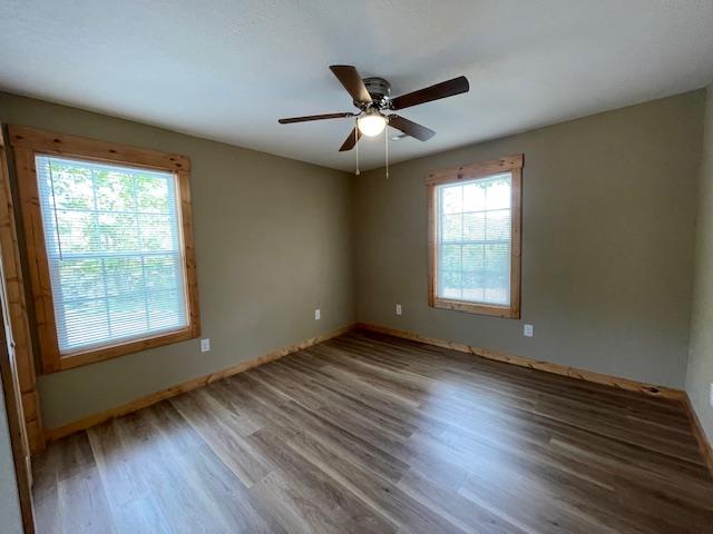 spare room featuring plenty of natural light, ceiling fan, and hardwood / wood-style flooring