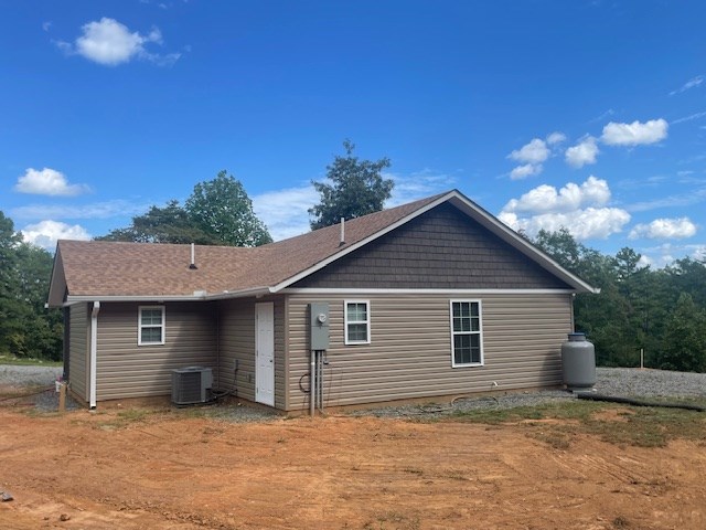 rear view of property featuring central AC