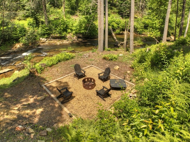 view of yard featuring a water view and an outdoor fire pit