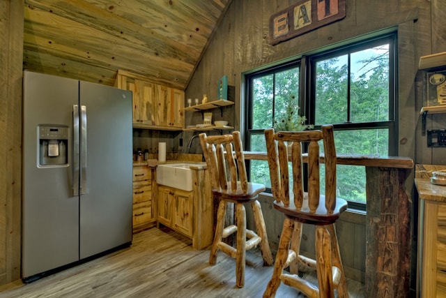 kitchen with stainless steel refrigerator with ice dispenser, lofted ceiling, sink, wooden ceiling, and light hardwood / wood-style floors