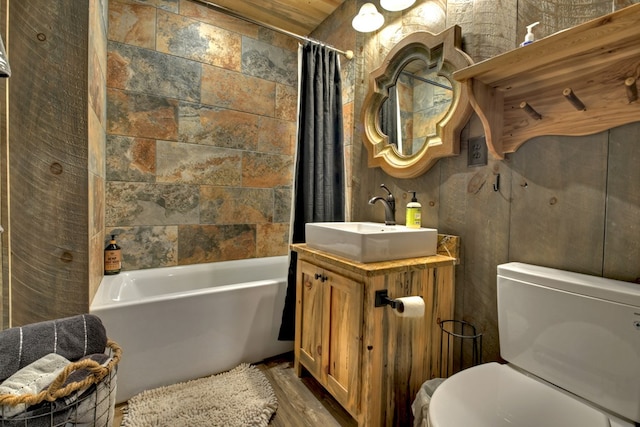 full bathroom featuring vanity, hardwood / wood-style flooring, shower / bath combination with curtain, and toilet