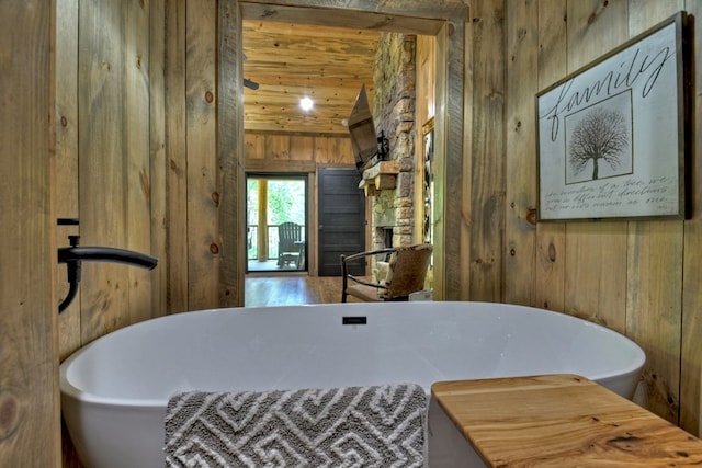 bathroom with wooden walls, wooden ceiling, and a tub