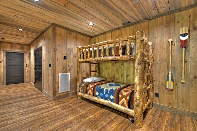 bedroom featuring wood ceiling, wood walls, and hardwood / wood-style flooring