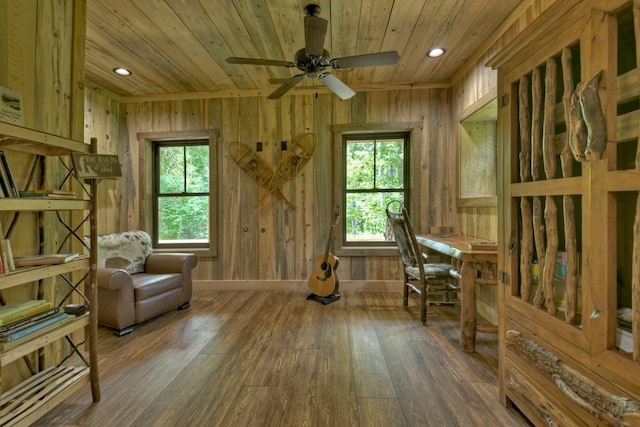 living area featuring wood walls, a healthy amount of sunlight, dark hardwood / wood-style floors, and wooden ceiling