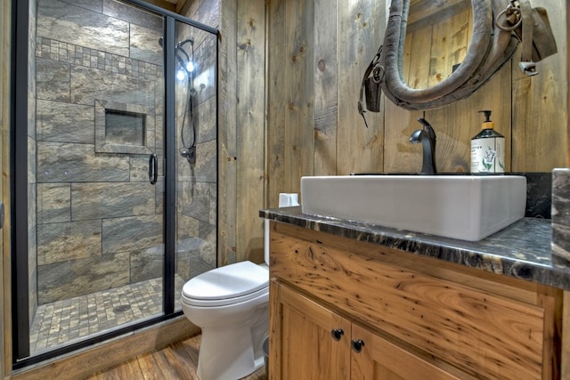 bathroom featuring vanity, toilet, a shower with shower door, and hardwood / wood-style floors