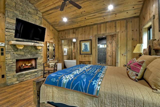 bedroom with lofted ceiling, hardwood / wood-style floors, a fireplace, wooden ceiling, and wood walls