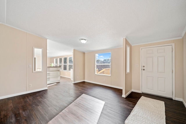 entryway with dark wood-type flooring, ornamental molding, and a textured ceiling