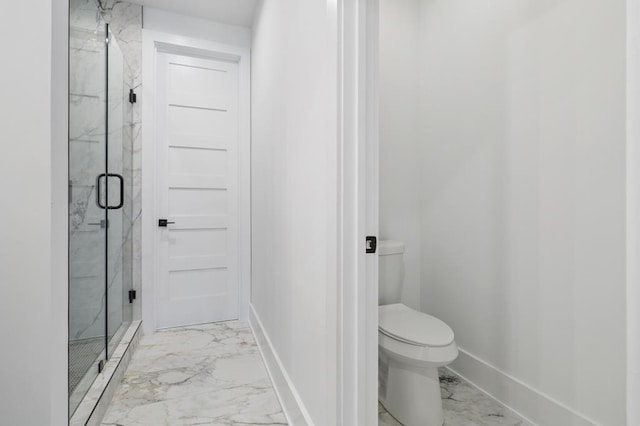 bathroom featuring toilet and a shower with shower door