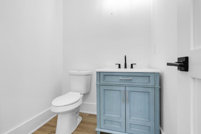 bathroom with vanity, wood-type flooring, and toilet