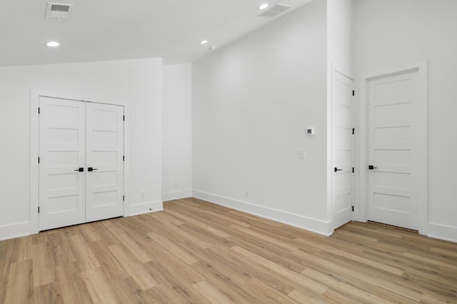 unfurnished room with light hardwood / wood-style floors and lofted ceiling